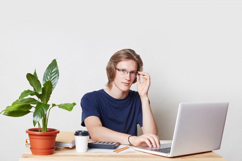 successful-businessman-works-home-sits-working-place-reads-terms-contract-uses-laptop-computer-with-free-internet-connection-productive-work-handsome-male-creates-business-plan_176532-6456.jpg